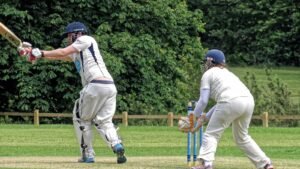 A batter playing a shot during a cricket match