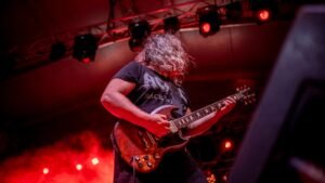 A guitarist performing under stage lights